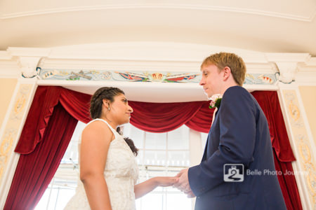 Couple getting married at altar velvet curtain